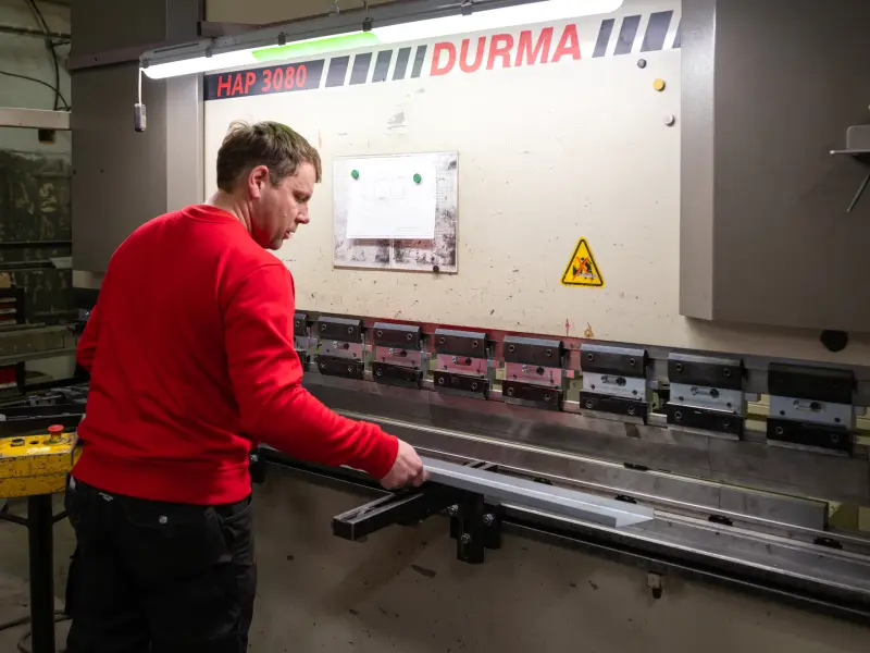 Pracovník ohýbá dlouhý plech na ohraňovacím lisu Durma